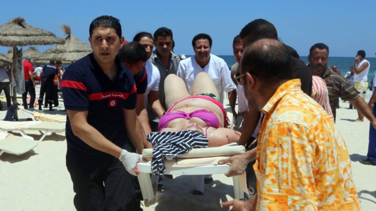 Una mujer herida es evacuada en una camilla, ayer, en la playa de Susa.