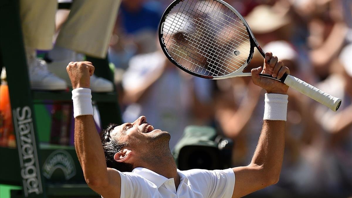 Djokovic celebra, a pie de pista, su triunfo en Wimbledon /