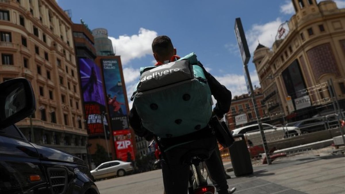 Un rider de Deliveroo realizando su reparto en su bicicleta.