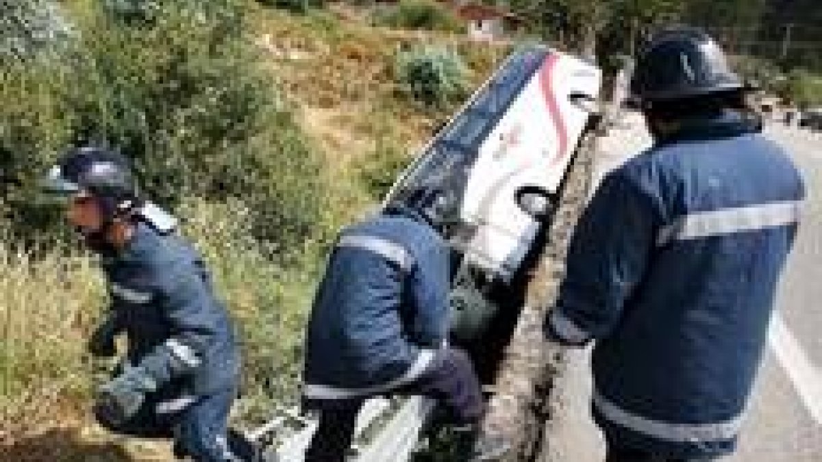 Los bomberos trabajan en la zona del siniestro, frente al autobús