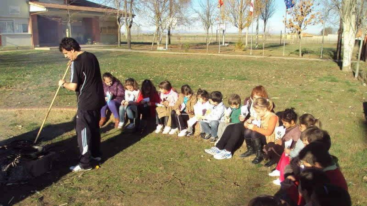 Los niños observan la preparación de las brasas.