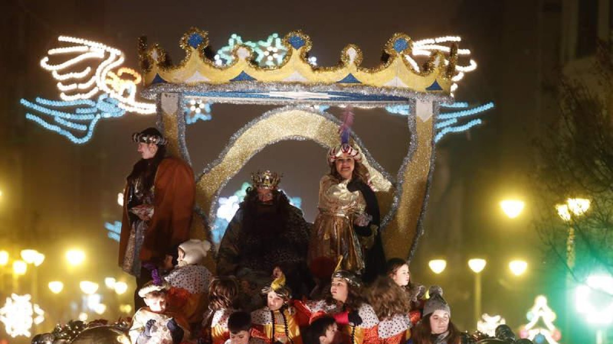 Gaspar, en su carroza y rodeado por niños de León, en su recorrido por las calles más céntricas de la capital, ayer. MARCIANO