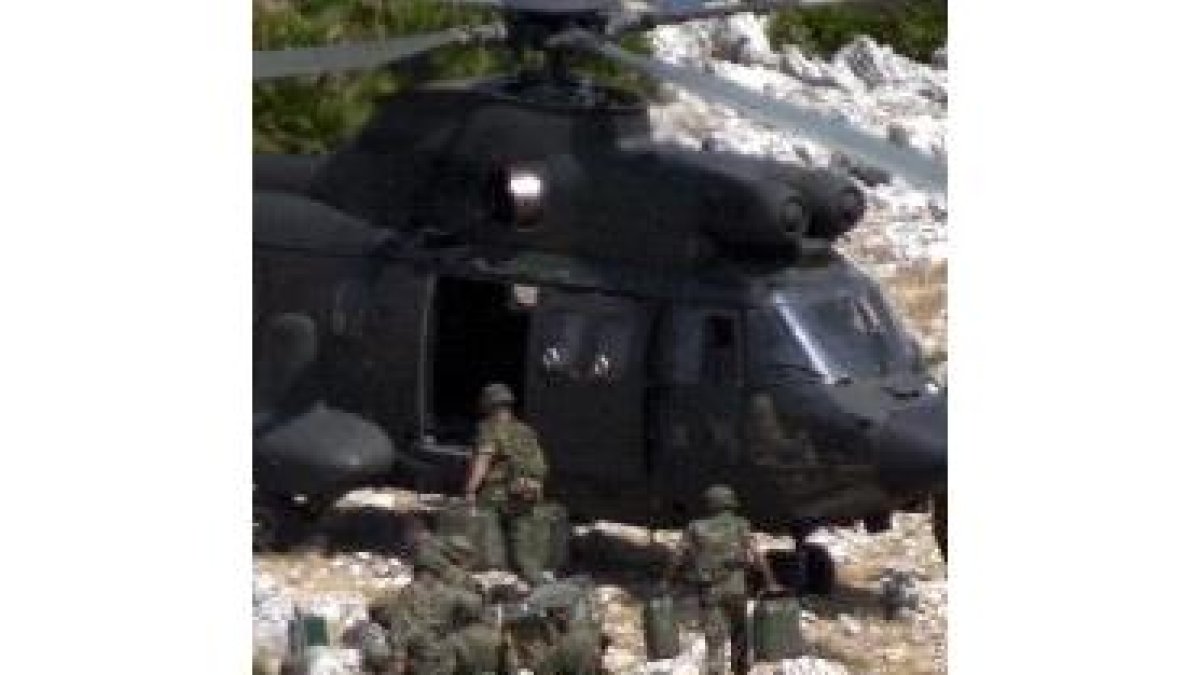 Los legionarios destacados en Perejil suben el material militar a un helicóptero y abandonan la isla
