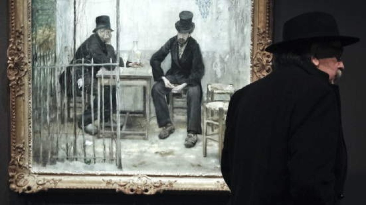 Un hombre pasa junto a la obra ‘Los bebedores de ajenjo / Los venidos a menos’, de Henri Fantin-Latour.