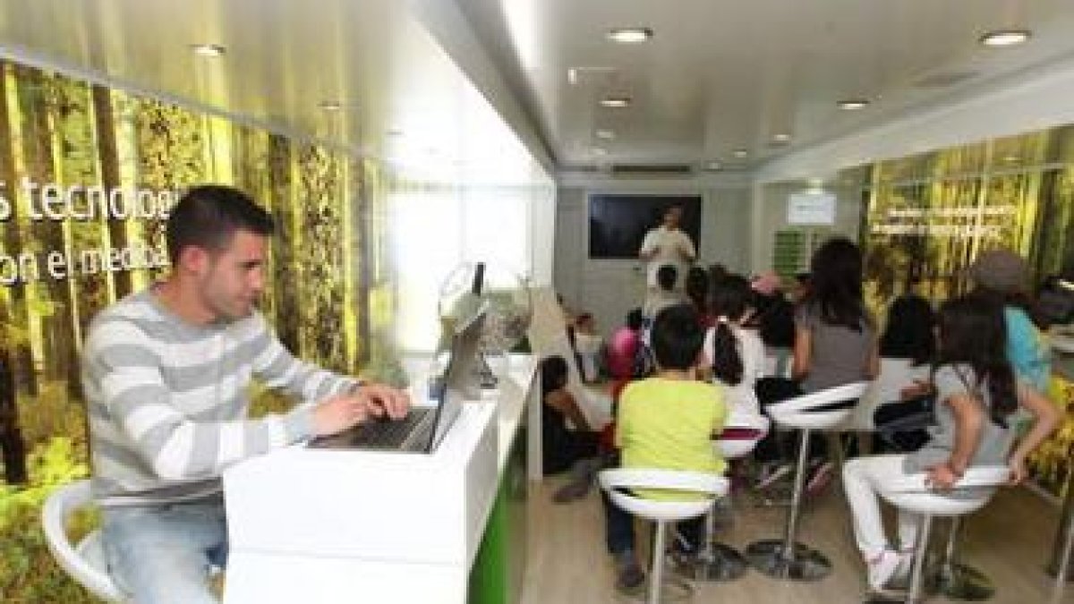 Un grupo de jóvenes siguen los juegos interactivos en el interior del autobús de Iberdrola.