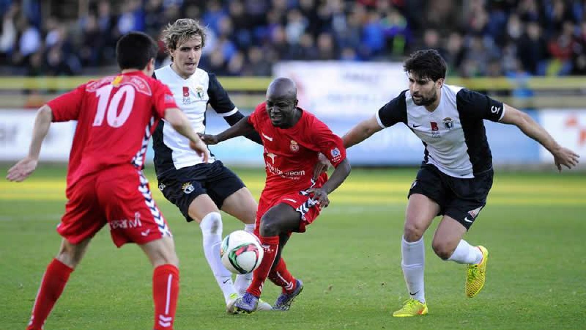 Babalola se lleva un balón ante dos contrarios.