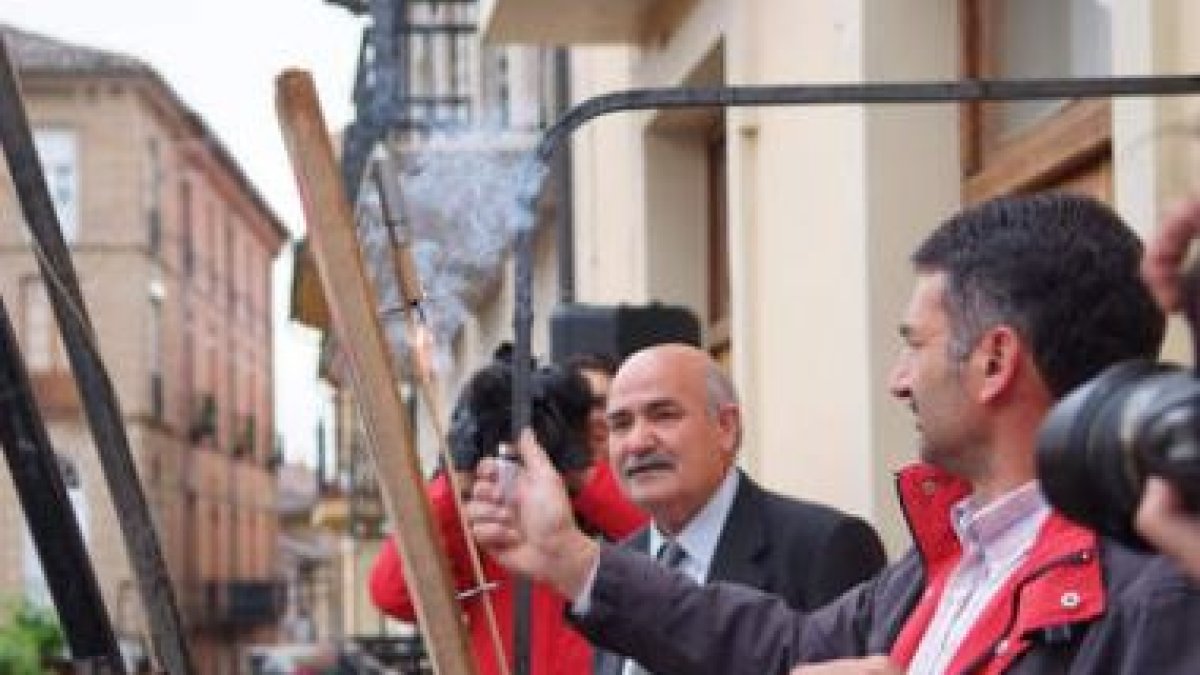 El alcalde, mechero en mano, observa cómo arde la mecha del cohete.