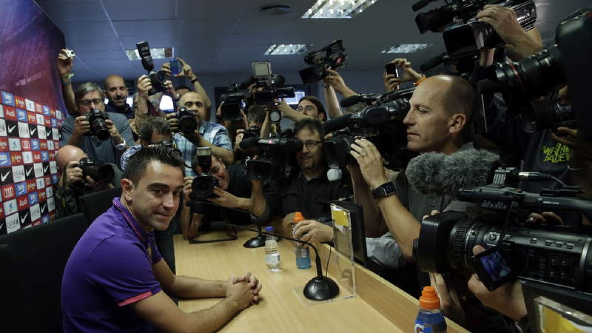 Xavi, rodeado de fotógrafos, en su despedida