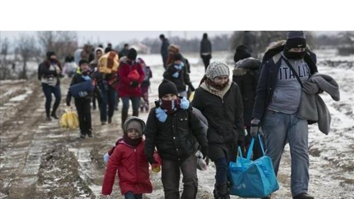 Familias de refugiados, muchos procedentes de Oriente Próximo, llegan a pie a Serbia, para continuar su viaje hacia Europa occidental, este lunes.