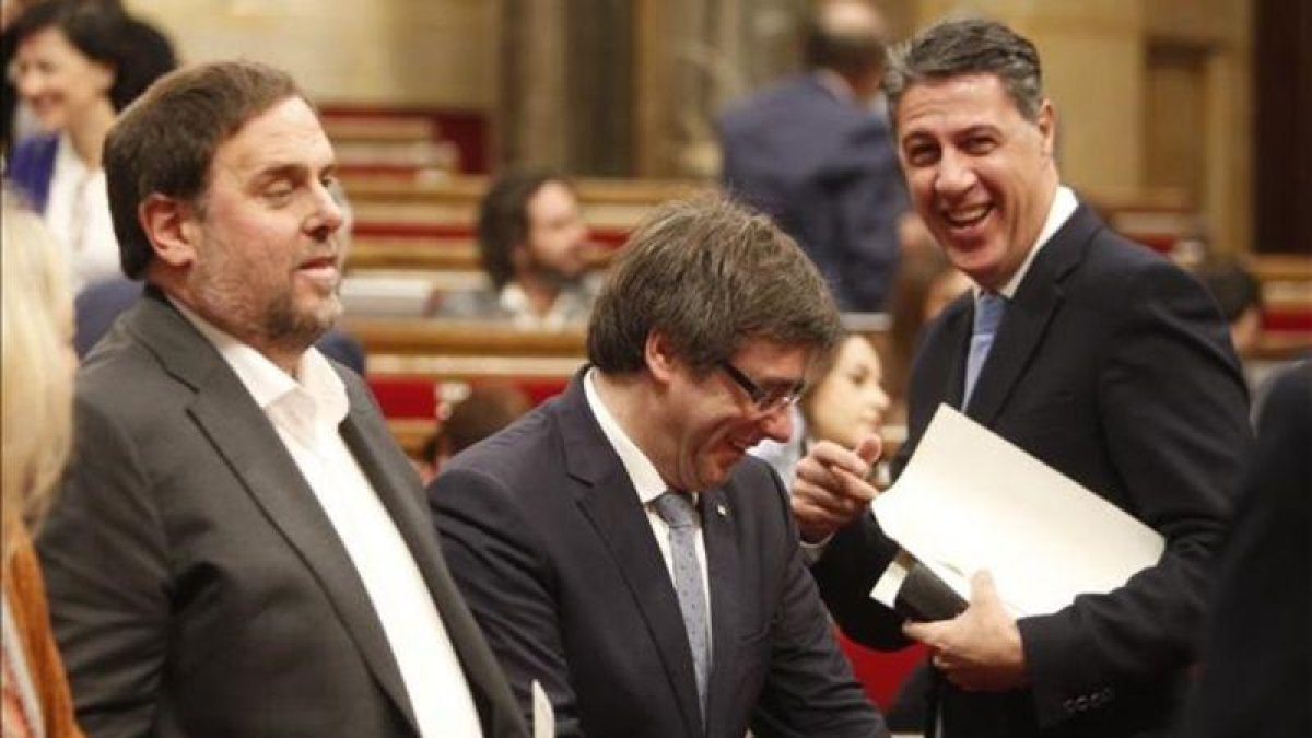 El líder del PPC en el Parlament, Xavier García Albiol, saluda al 'president' Carles Puigdemont, antes de una sesión de control en el Parlament.