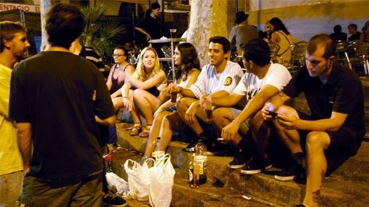 Un grupo de jóvenes hace botellón en una plaza de Barcelona.