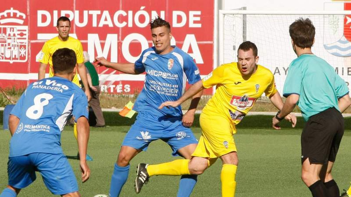 Álex Matos, autor del segundo gol bañezano, se lleva un balón entre dos contrarios. LA OPINIÓN DE ZAMORA