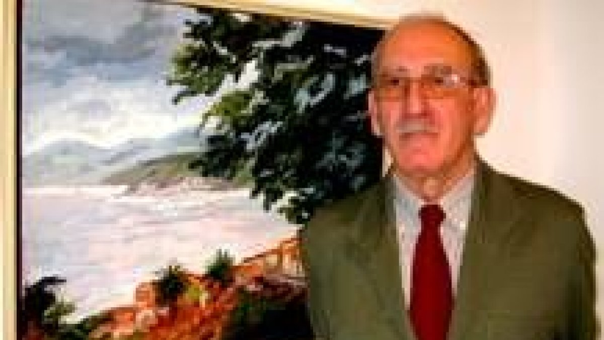 Jaime Rollán posa junto uno de sus cuadros expuestos en Casa de Carnicerías