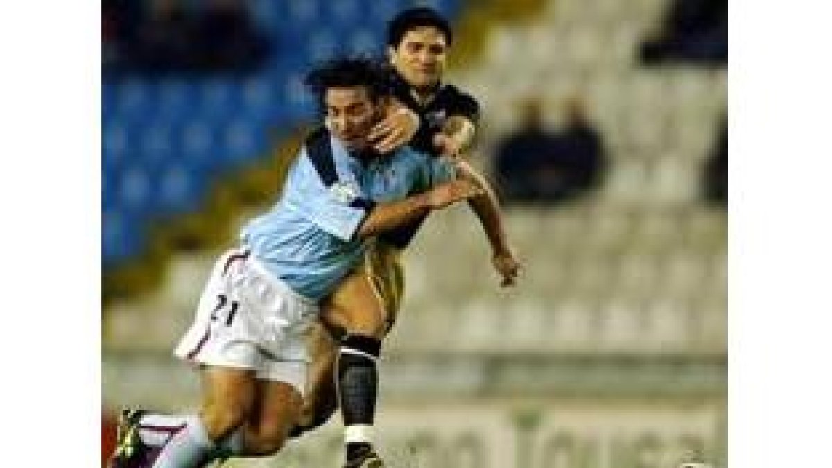 El céltico Jorge Castro es obstaculizado en una acción por el jugador malacitano Rojas