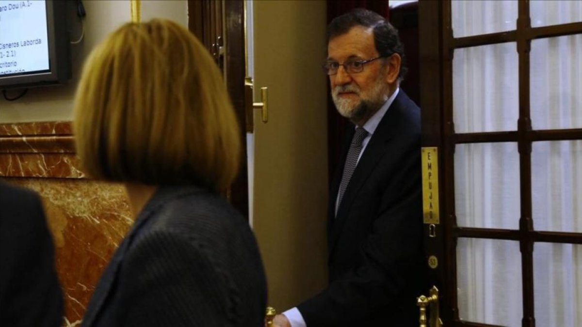 El presidente del Gobierno, Mariano Rajoy, y la ministra de Defensa, María Dolores de Cospedal, en los pasillos del Congreso.