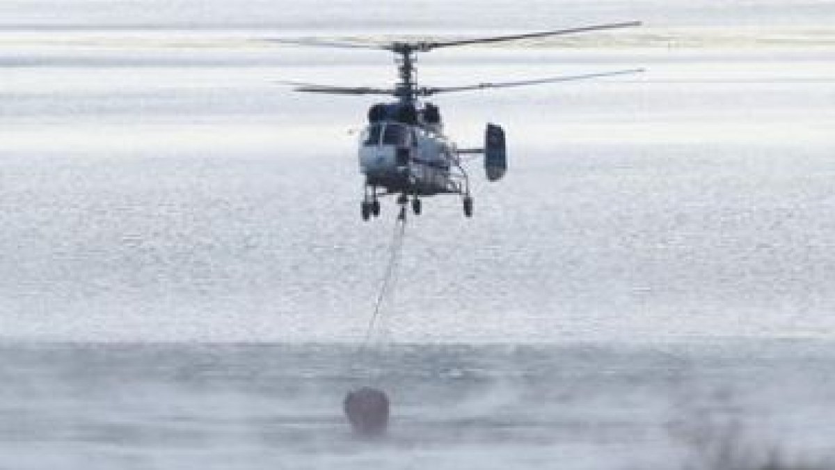 Un helicóptero carga agua en Riaño.