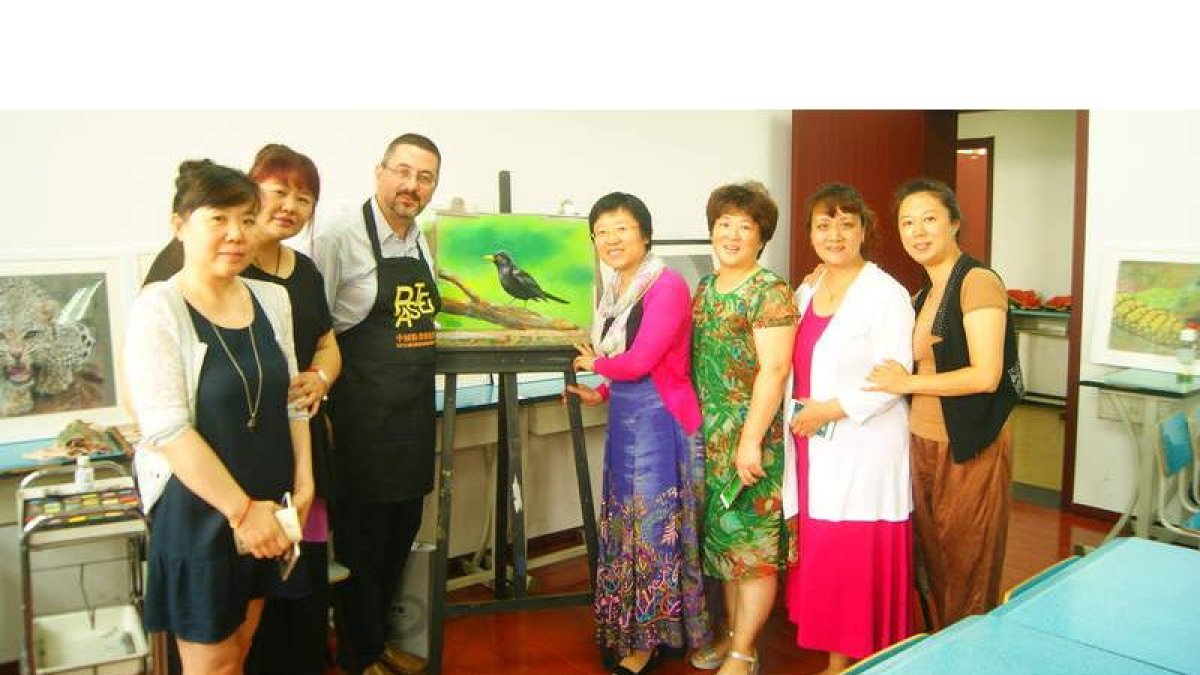 El pintor asturiano, residente en La Mata de Curueño, posa con algunas de sus alumnas tras una de sus clases sobre pintura al pastel en Pekín. DL