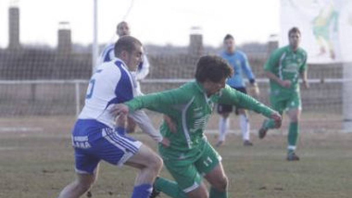 Alfonso (d), controla el balón a pesar de la oposición de Pedro.