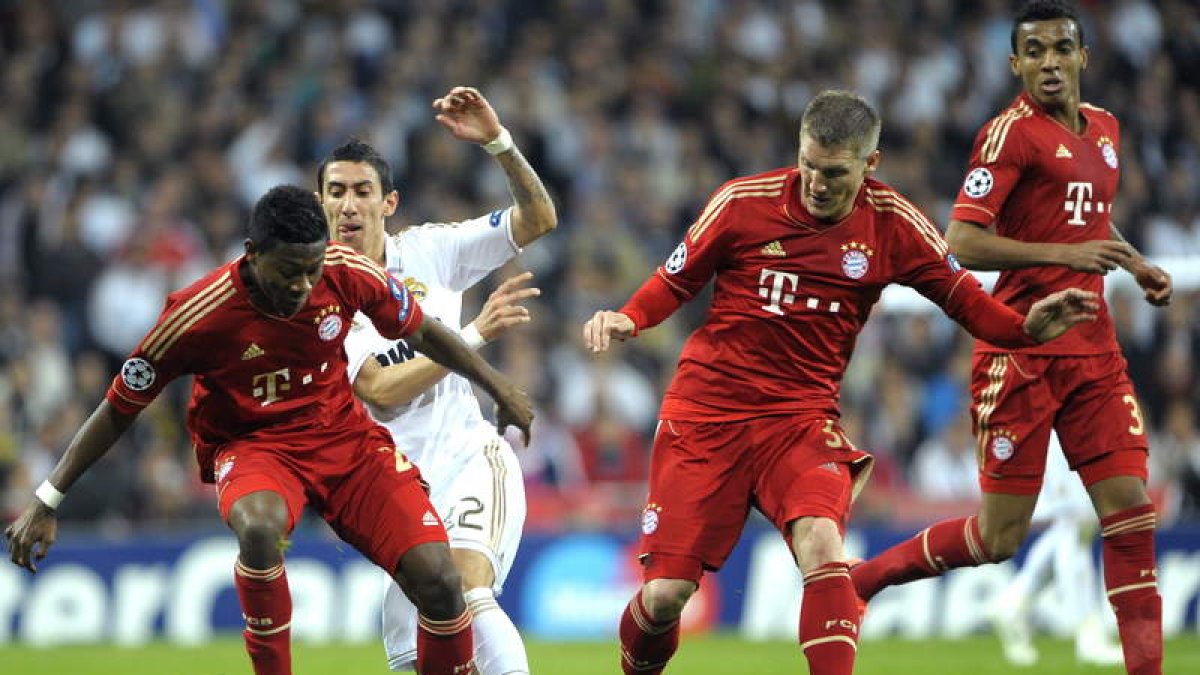 Di Maria, a la izquierda, pelea un balón con Schweinsteiger.