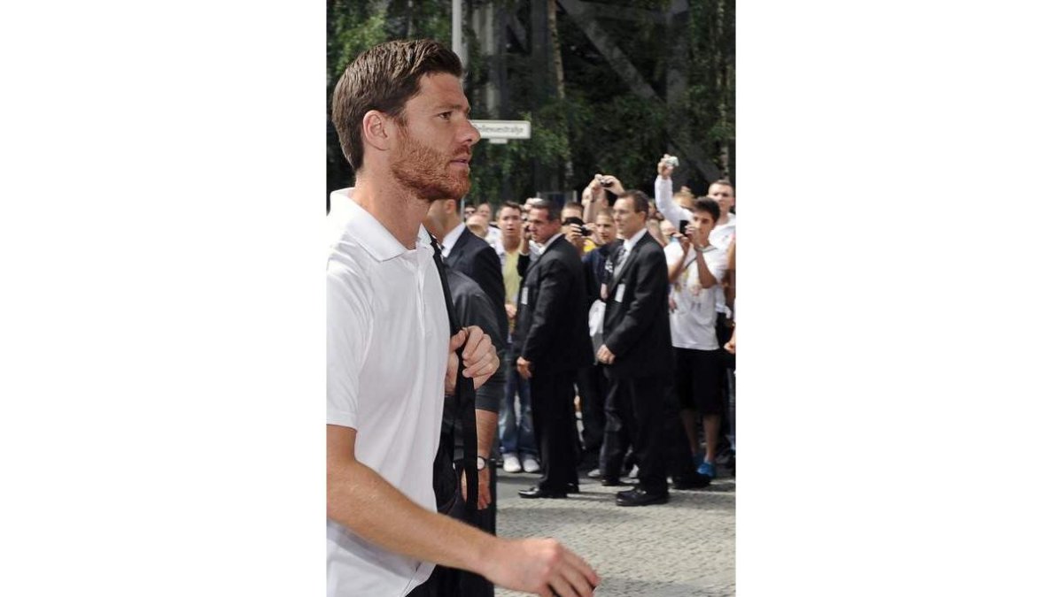 Los responsables de seguridad protegen a Xabi Alonso.