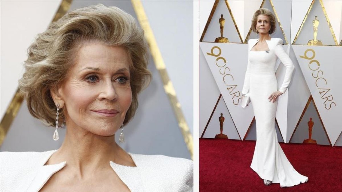 Jane Fonda luce su chapita Times Up en su Balmain blanco impoluto,  con hombreras y escote cuadrado puntiagudo.