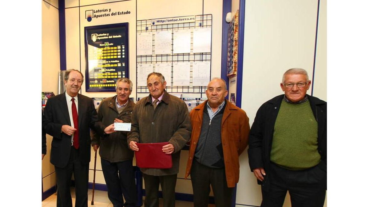 Una representación de El Gallo de Oro recibe el cheque.