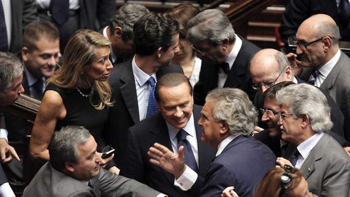 Un grupo de diputados rodea a Silvio Berlusconi tras superar la moción de confianza.