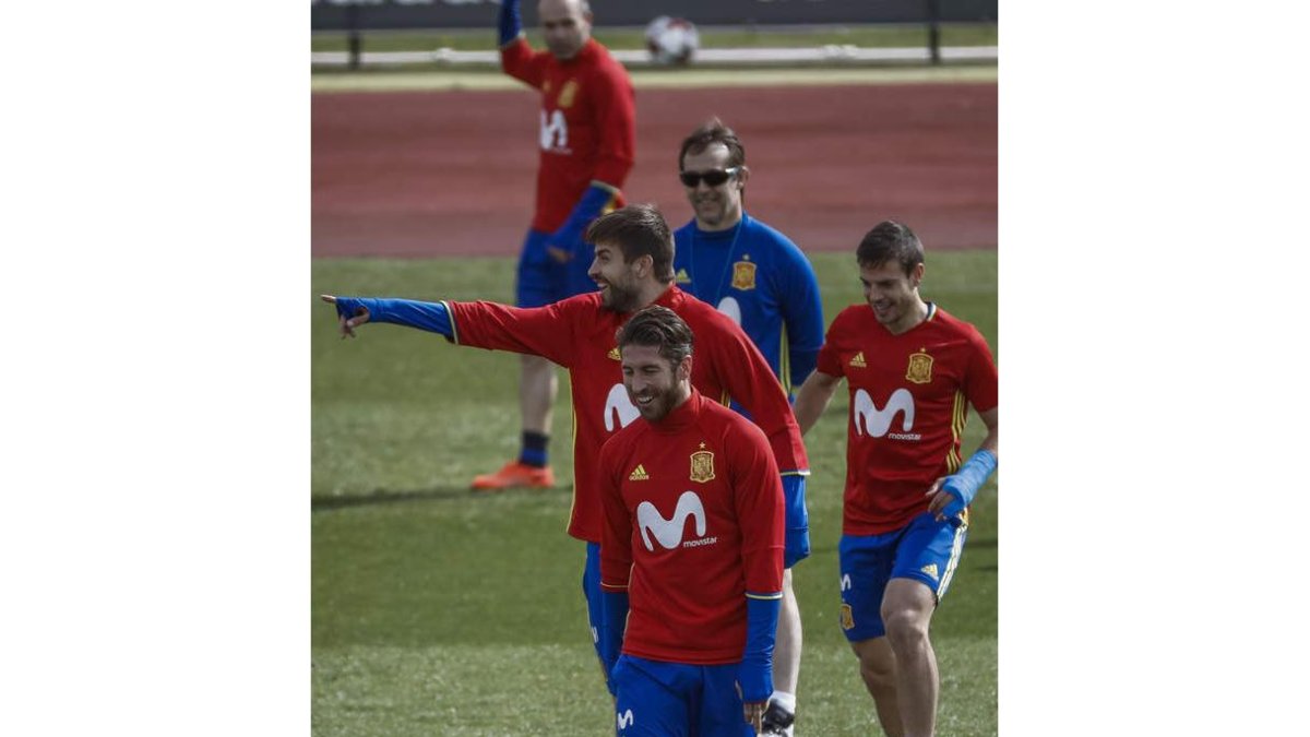 El seleccionador Julen Lopetegui, con gafas de sol, observa las risas entre Ramos y Piqué. EMILIO NARANJO