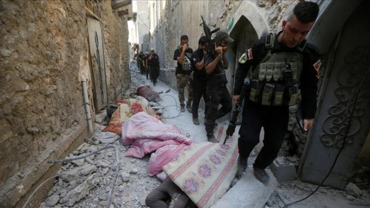 Miembros de los equipos antiterroristas iraquís pasan junto a cadáveres de combatientes del Estado Islámico en una calle de la ciudad vieja de Mosul.