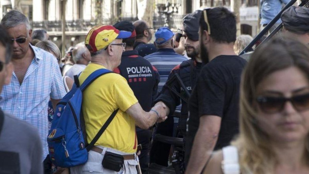Un ciudadano saluda y felicita a los Mossos por su actuación durante los atentados.