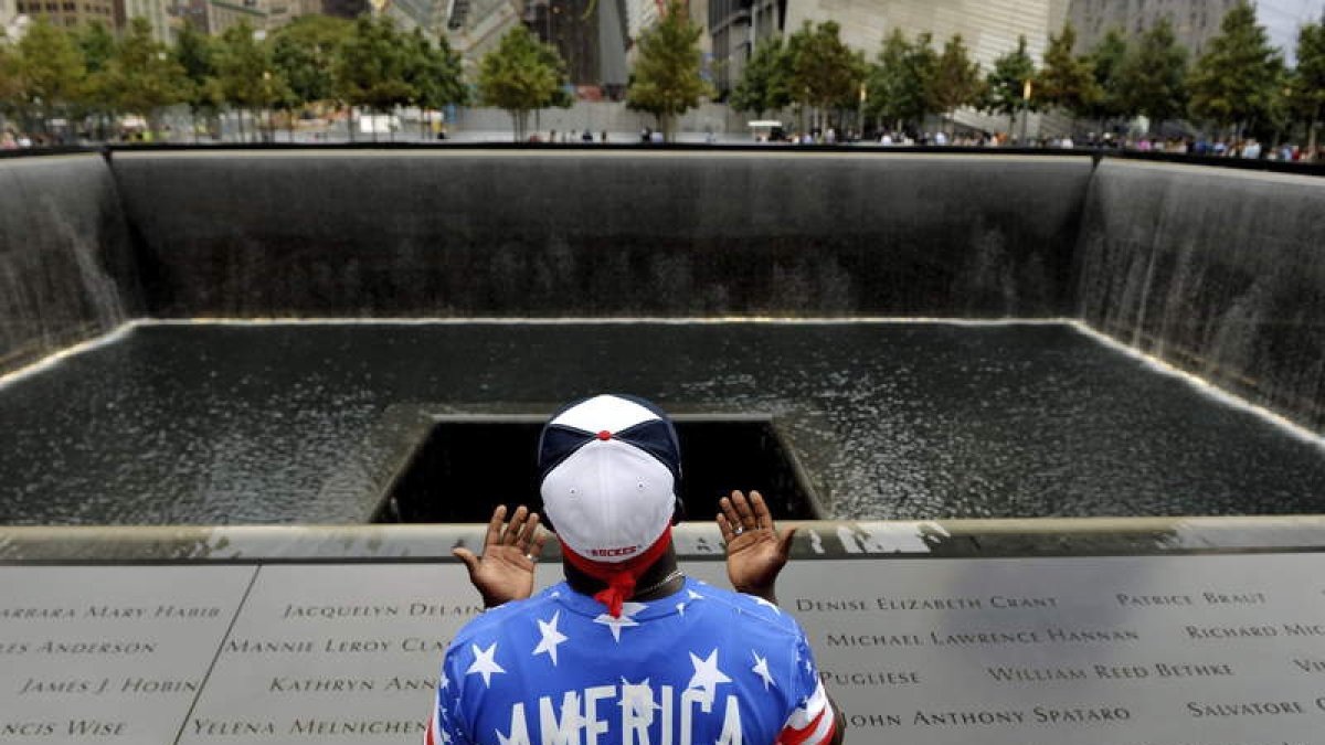 Un hombre reza en la piscina de la torre norte durante un acto en memoria de las víctimas de los ataques del 11S.