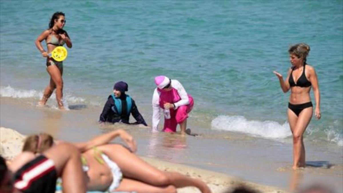 Mujeres con 'burkini' en una playa del sur de Francia, el lunes.