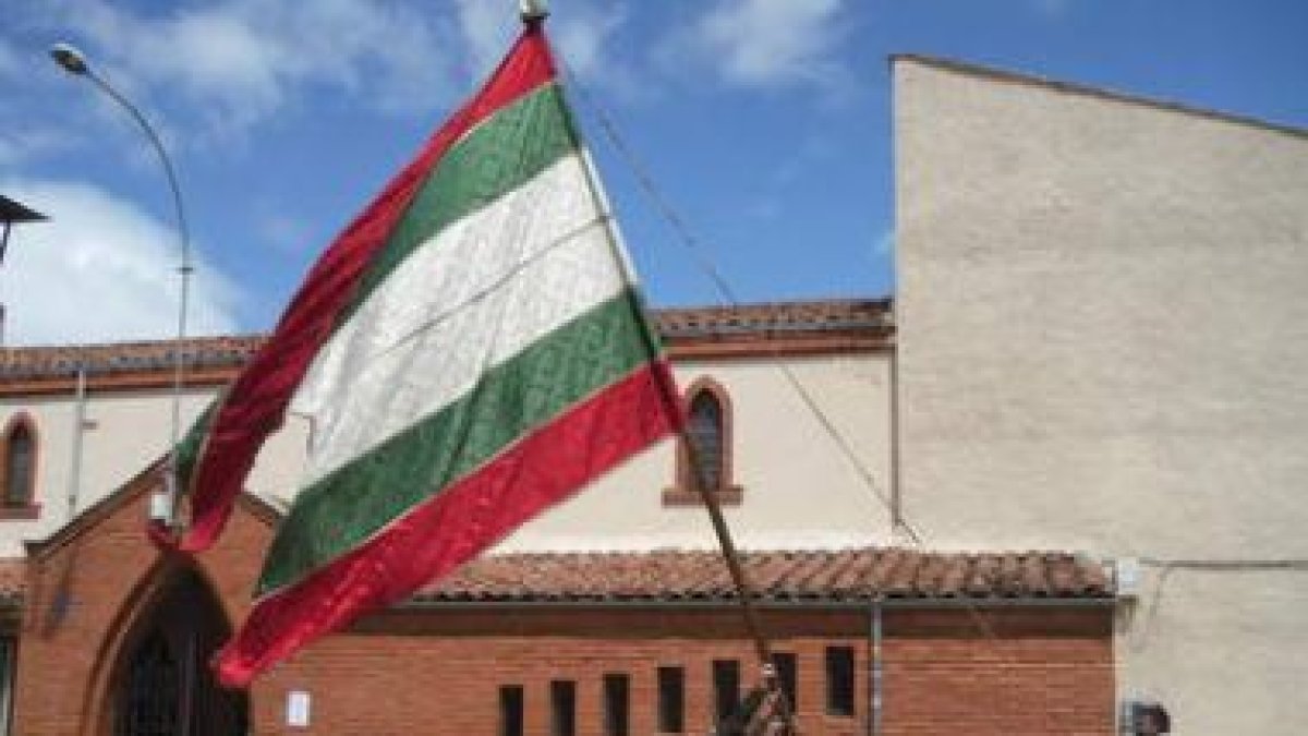 Los vecinos de Arcahueja alzan por primera vez su nuevo pendón.
