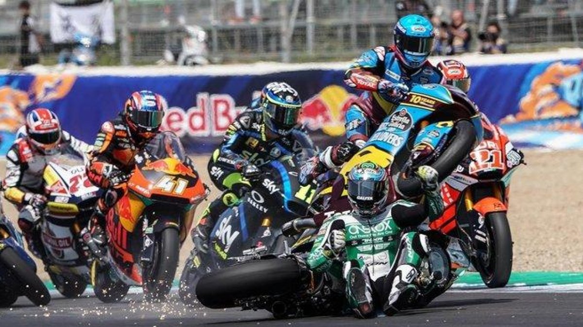Àlex Márquez (Kalex), a la derecha, con casco azul, salta, vuela, por encima de la moto y el cuerpo del australiano Remy Gardner, sentado ya en la pista tras su caída, en la salida de hoy de Moto2, en Jerez.