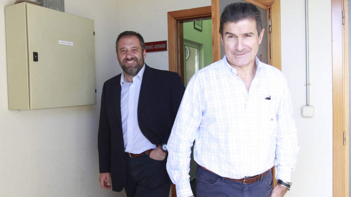Manuel Cadenas a su salida ayer del club leonés después de haber dado el «sí» a regresar al banquillo del Ademar. A su espalda, un satisfecho Carlos Pollán.