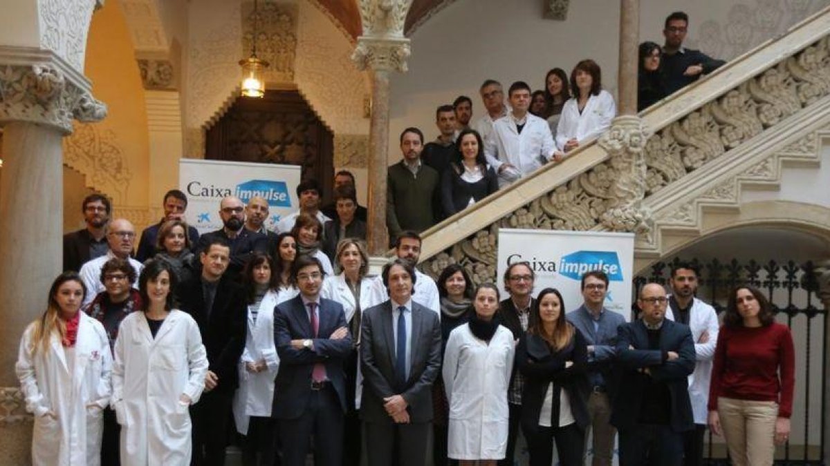Los participantes en CaixaImpulse posan en el Palau Macaya con Carles Trenchs y Jordi Portabella al frente.