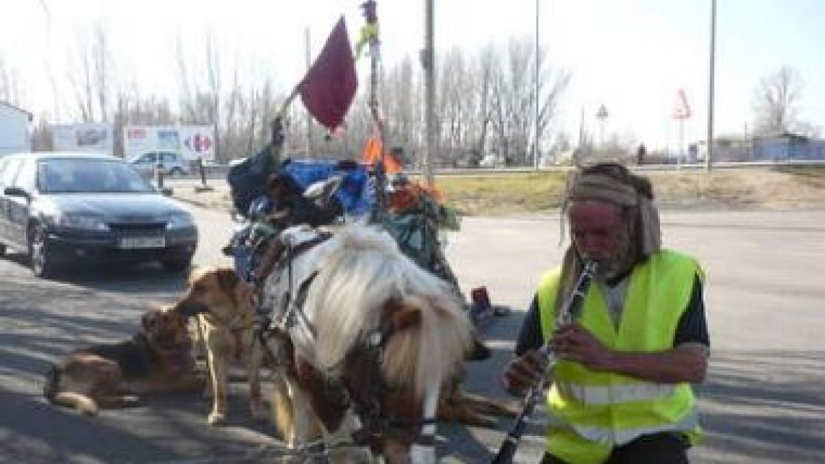 Carlos, tocando ayer para sus perros mientras descansaban a la salida de León.