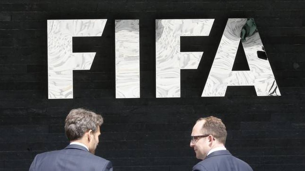 Dos hombres pasan por delante de la sede central de la FIFA en Zúrich.