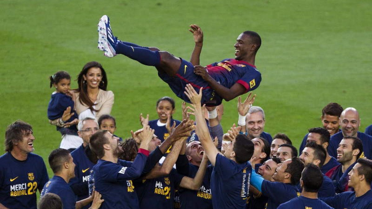 El defensa Eric Abidal es manteado por sus compañeros durante el homenaje que recibió ayer.