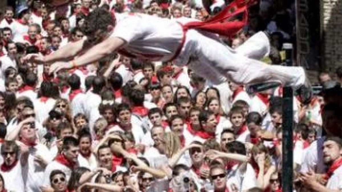 Un joven se lanza desde la fuente de Navarreira tras el tradicional chupinazo.