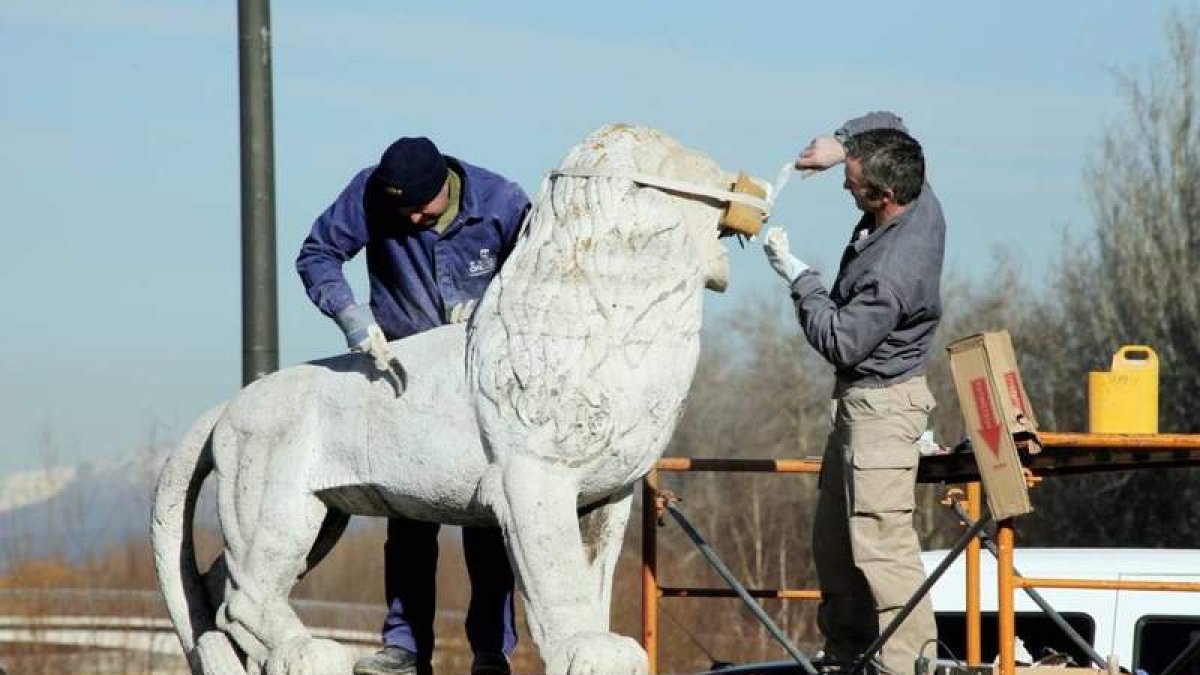 Tarbajadores del Centro de Artes y Oficios restauran uno de los leones del puente.