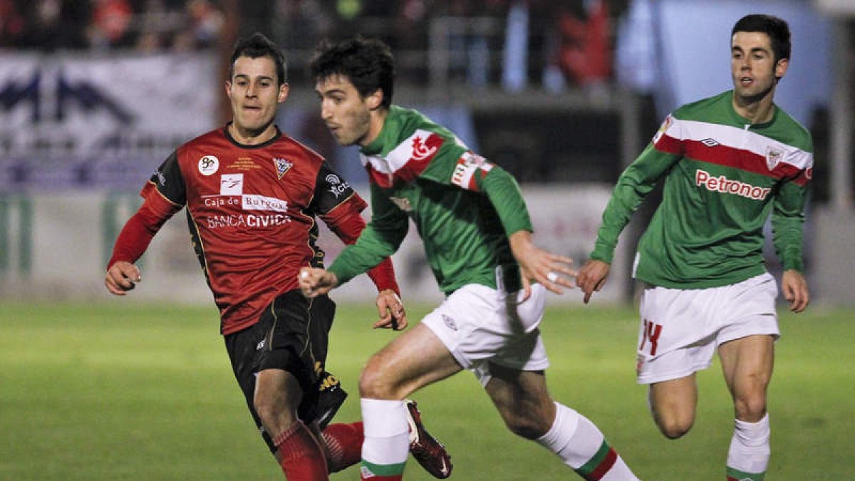 El jugador del Athletic Susaeta escapa de Raúl García del Mirandés durante el partido de ayer en Miranda de Ebro.