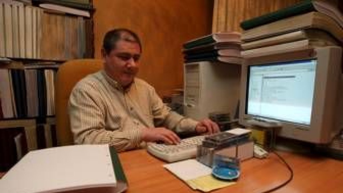 Armando Castellanos con sus carpetas de braille y el ordenador adaptado en su casa