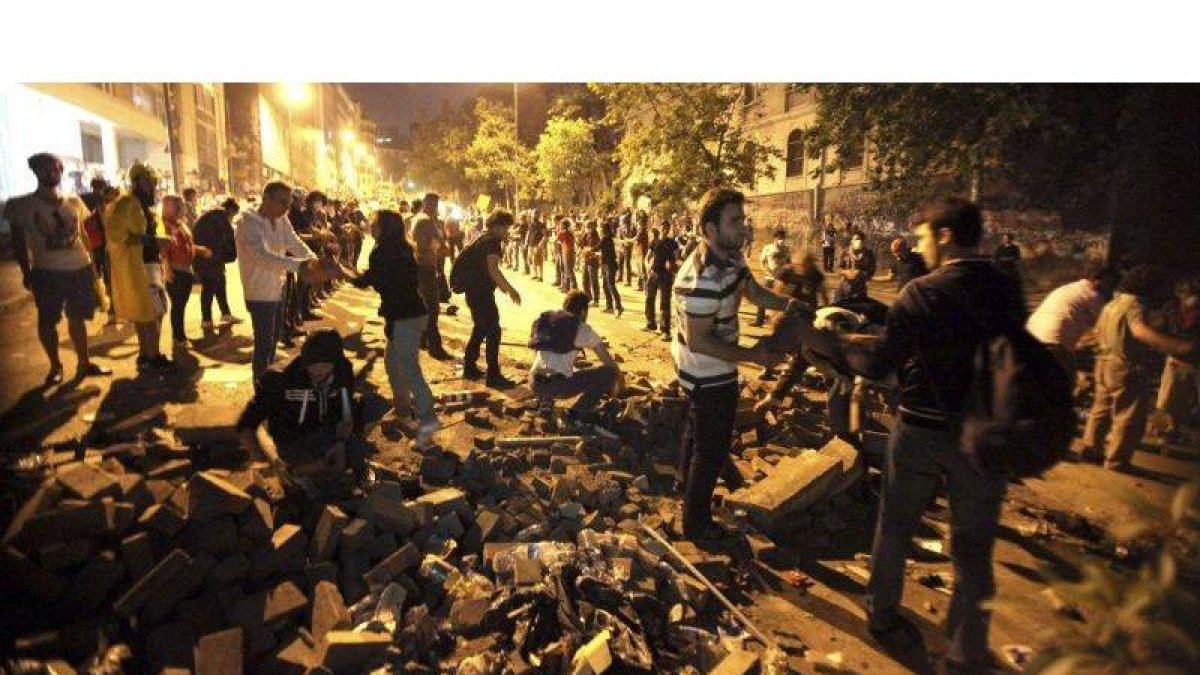 Manifestantes construyen una barricada con ladrillos y piedras en una calle en Estambul.