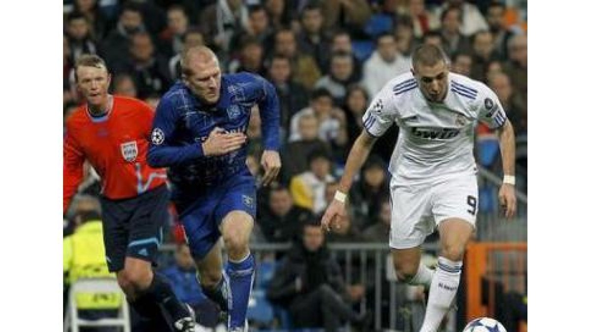 Benzema intenta zafarse del marcaje de un defensor del Auxerre para marcar su primer gol.