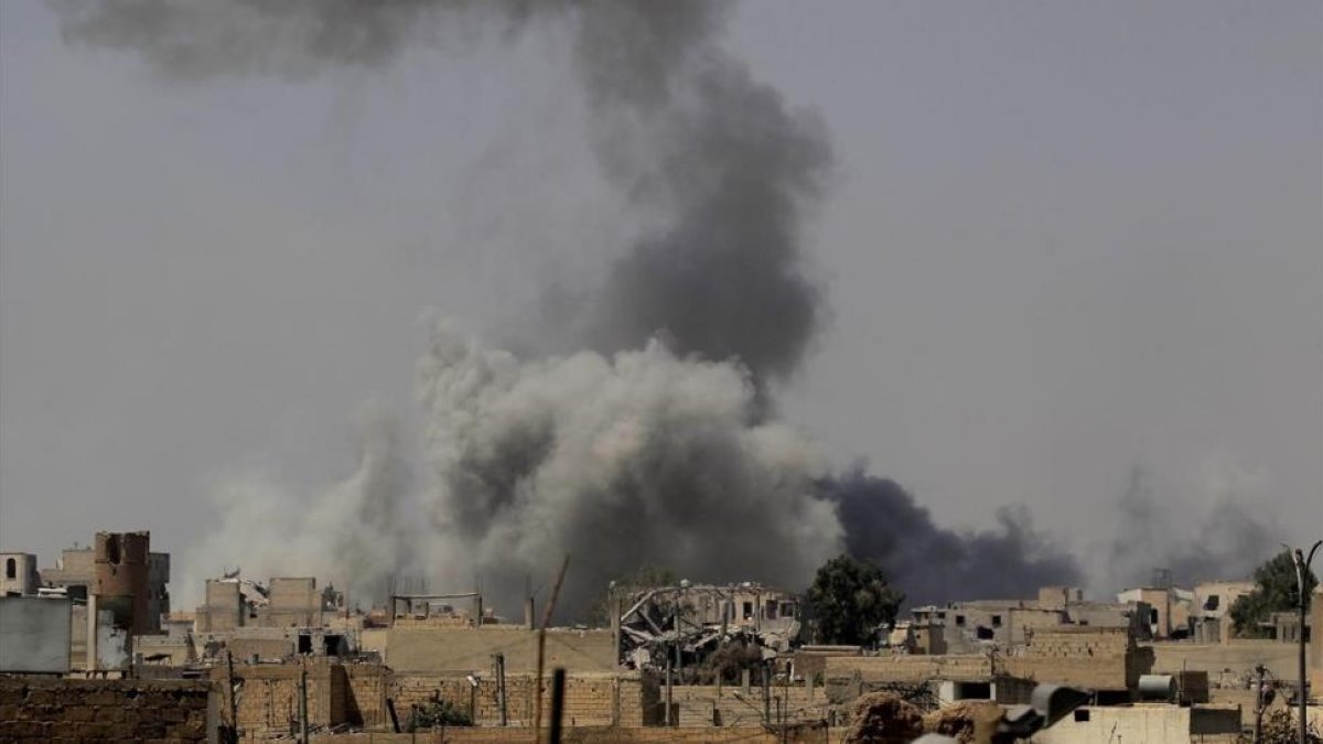 Una densa humareda sube hacia el cielo en los combates entre las Fuerzas Democráticas Sirias y el Estado Islámico en Raqqa (Siria), el 20 de agosto