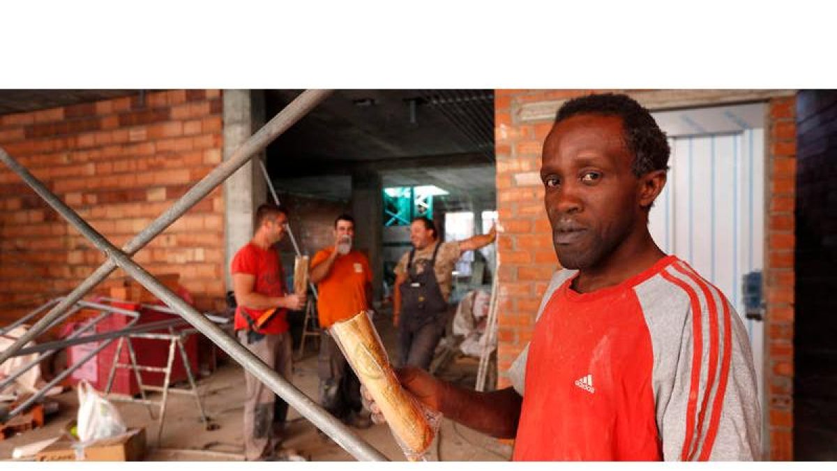 Los trabajadores de la construcción Agustine, en primer plano, Jorge, Roberto y David, durante el descanso de media mañana para comer el bocadillo. JESÚS F. SALVADORES