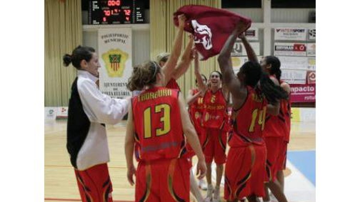 Las jugadoras del Feve San José celebran la victoria como una piña en el centro y con la bandera de