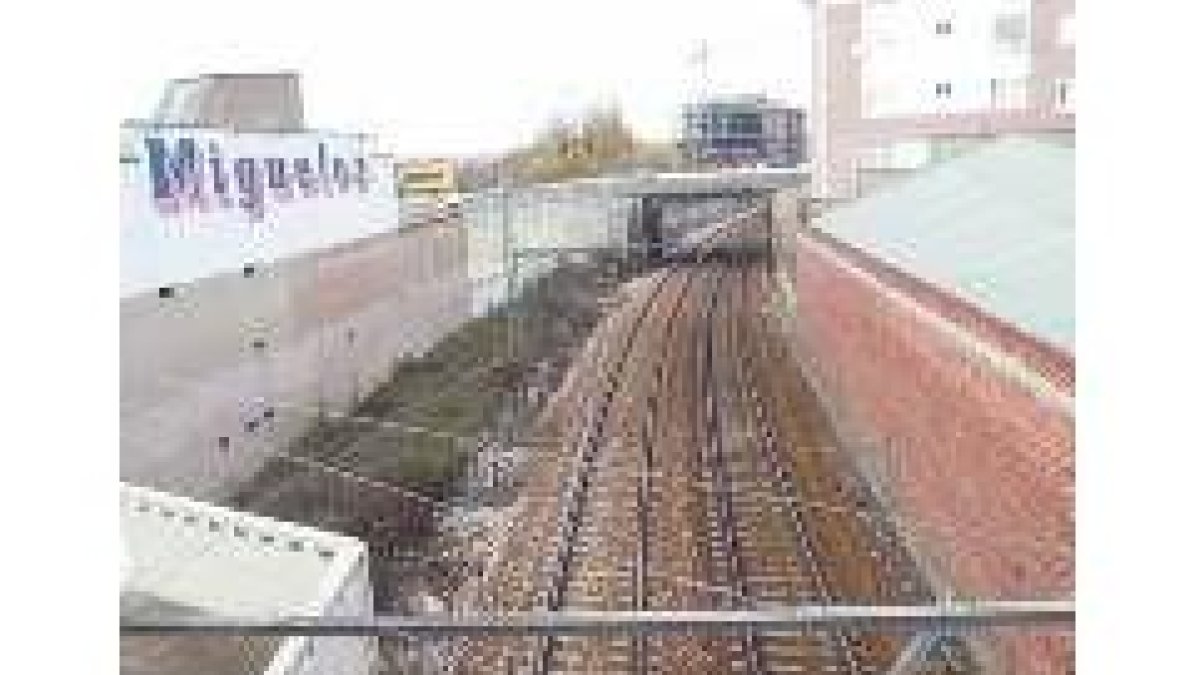 Tramo de vía ferroviario correspondiente al cruce con la carretera N-120 y la línea León-Gijón
