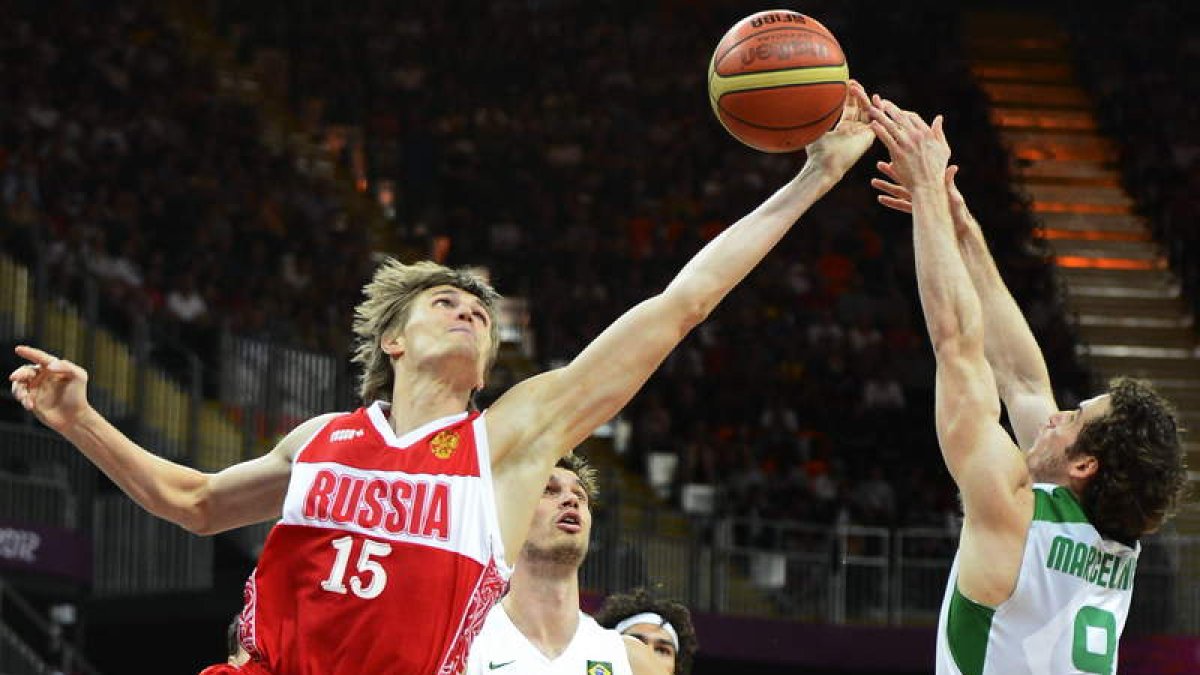 Kirilenko (i) lucha con Huertas por un rebote defensivo.